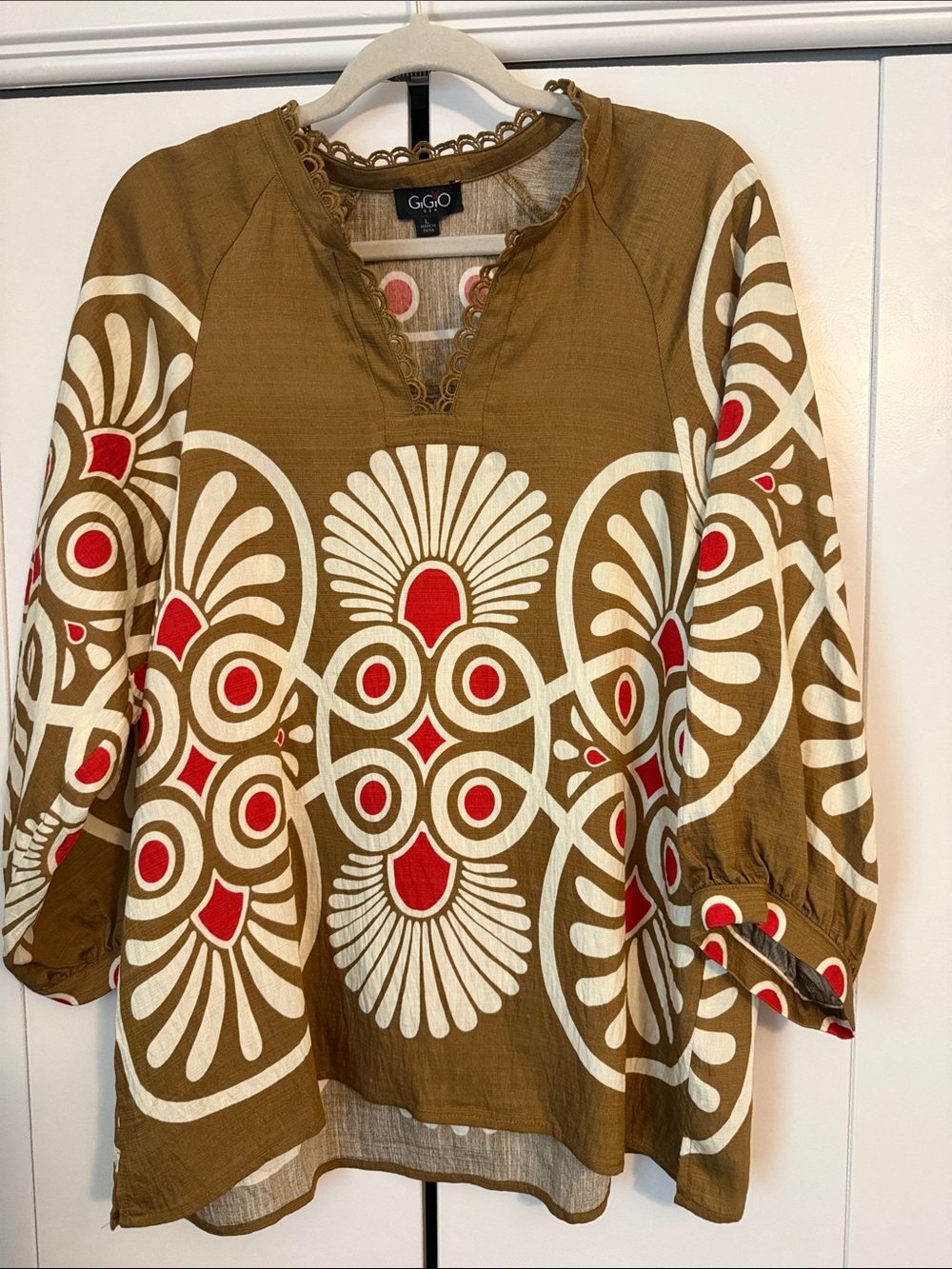 This is a GiGiO printed notch neck top size Large